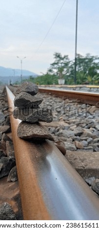 A pile of stones on the train tracks displays the balance of nature