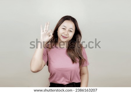 Portrait of a young Asian woman Woman smiling and giving OK sign