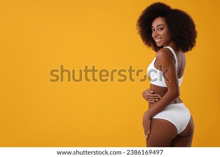 Beautiful woman in stylish bikini on yellow background, space for text