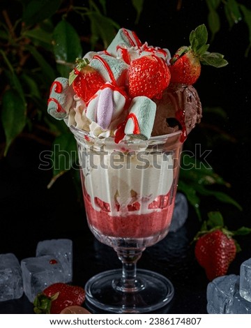 A cup of ice cream with chocolate, vanilla, strawberries and marshmallow