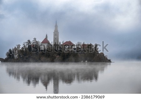 The famous Alpine Lake Bled (Blejsko jezero) in Slovenia, an amazing autumn landscape. Fabulous view of the lake, island with church, and foggy autumn morning.
