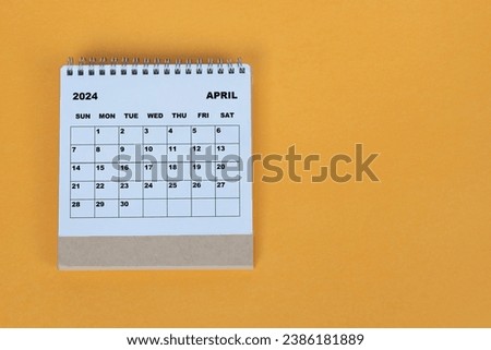 April 2024 desk calendar on yellow background. Directly above. Flat lay. Royalty-Free Stock Photo #2386181889