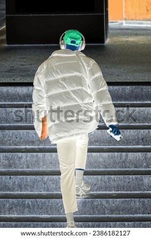 Man on stairway with baseball cap and headphones at Swiss City of Zürich district Oerlikon on a cloudy autumn day. Photo taken October 27th, 2023, Zurich, Switzerland.