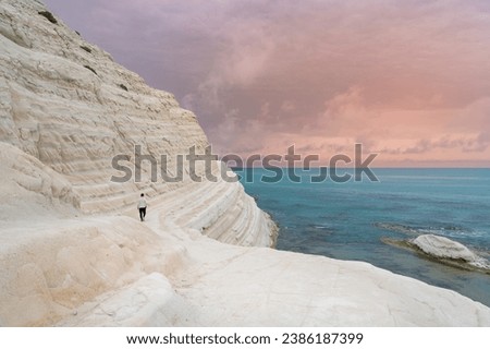 Young man admiring the white limestone cliffs of the Scala dei Turchi, Agrigento, Sicily, Italy, 