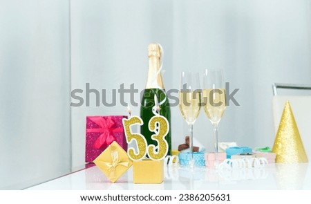 Date of birth with number  53. Festive Champagne in glasses with gift boxes, anniversary postcard. Happy birthday golden candles.