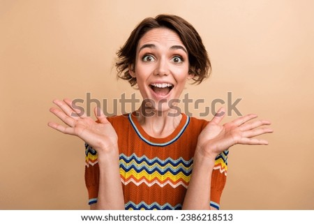 Portrait of impressed positive girl raise opened arms palms cant believe isolated on beige color background Royalty-Free Stock Photo #2386218513