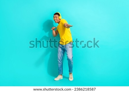 Full body photo of young guy enjoy his itunes playlist music wireless earphones dancing cool party isolated on aquamarine color background