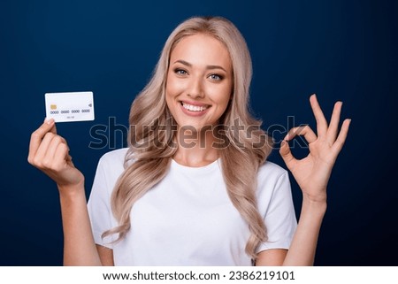 Photo of gorgeous satisfied girl wear stylish white clothes showing okey sign credit card isolated on dark blue color background