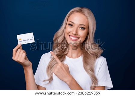 Photo of lovely stunning girl wear white clothes presenting bank card nfc payment isolated on dark blue color background