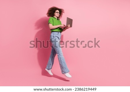 Full length photo of cheerful excited girl dressed trendy clothes walking empty space writing sms message isolated on pink color background