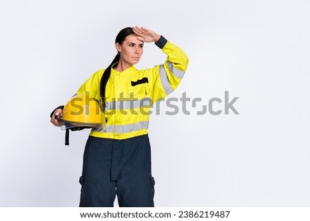 Photo of confident serious firewoman dressed uniform helmet looking far away empty space arm forehead isolated white color background