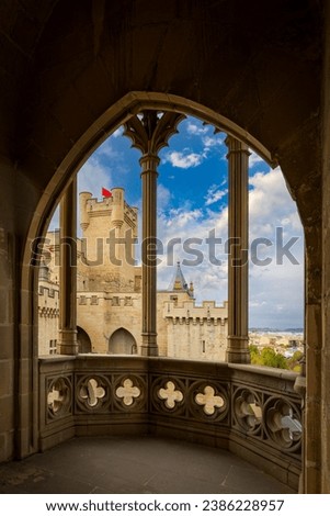 Vertical photo of a Gothic balcony of one of the towers of the Olite castle in Navarra, Spain with the palace in the background