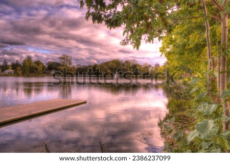 Showing a dock and fountain on a park lake background.
