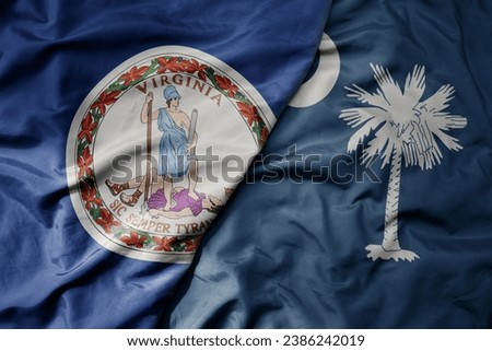 big waving colorful national flag of south carolina state and flag of virginia state . macro