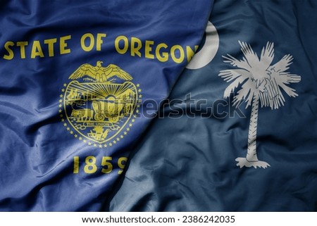 big waving colorful national flag of south carolina state and flag of oregon state . macro