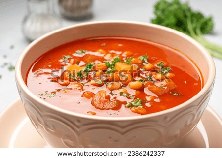 Greek bean soup Fasolada with tomatoes, carrot, celery and onion in bowl on concrete background. Selective focus.