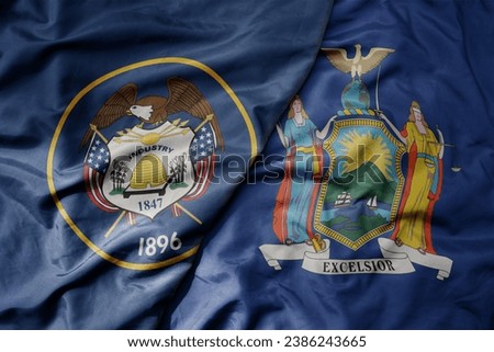 big waving colorful national flag of new york state and flag of utah state . macro