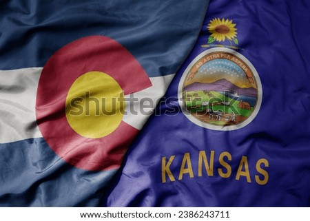 big waving colorful national flag of kansas state and flag of colorado state . macro