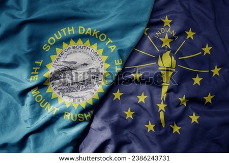big waving colorful national flag of indiana state and flag of south dakota state . macro