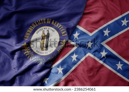 big waving colorful confederate jack flag and flag of kentucky state . macro