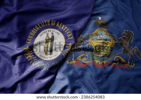 big waving colorful national flag of pennsylvania state and flag of kentucky state . macro