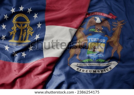 big waving colorful national flag of michigan state and flag of georgia state . macro