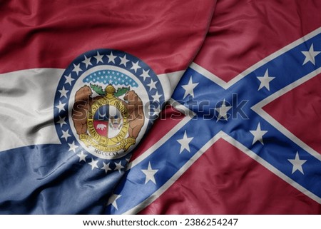 big waving colorful confederate jack flag and flag of missouri state . macro