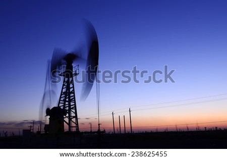 The pumping unit is a homework, in the oil field in the evening 