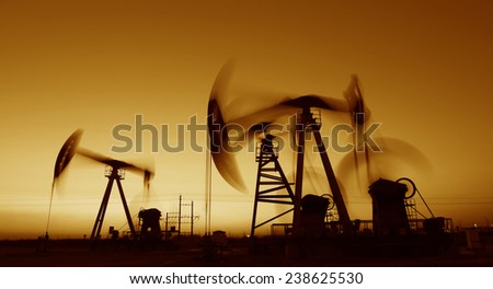 Many are operation of pumping unit, the oilfield in the evening  