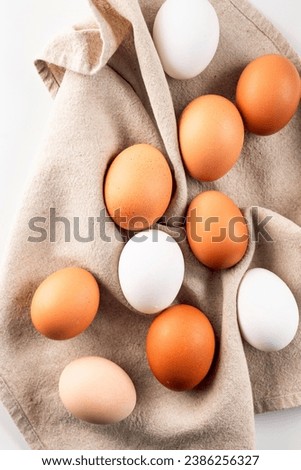 Close up of raw Fresh brown and white chicken eggs in an egg crate on natural linen napkin, food ingredients concept.