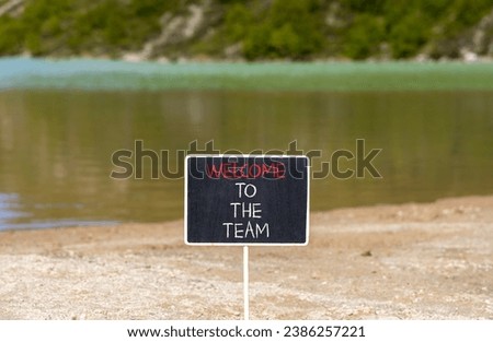 Welcome to the team symbol. Concept words Welcome to the team on beautiful black chalk blackboard. Beautiful mountain lake background. Business, motivational and welcome to the team concept.