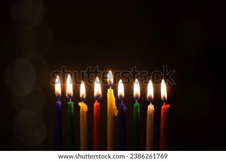 Closeup of Hanukkah menorah, or hanukkiah for Jewish holiday Hanukkah. Nine colored candles. Hanukkah lamp, nine-branched candelabrum. Royalty-Free Stock Photo #2386261769
