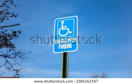 blue and white handicap parking sign against a blurred urban backdrop, symbolizing accessibility and inclusivity