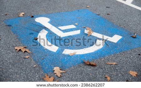 blue and white handicap parking sign against a blurred urban backdrop, symbolizing accessibility and inclusivity