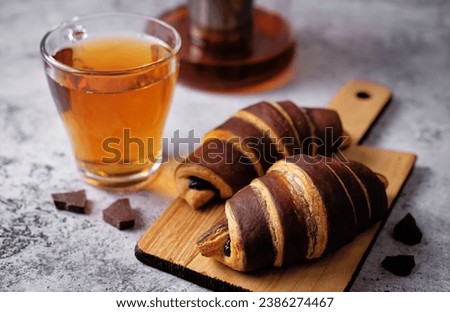 Croissants with chocolate crust and chocolate filling with cup of tea. toning