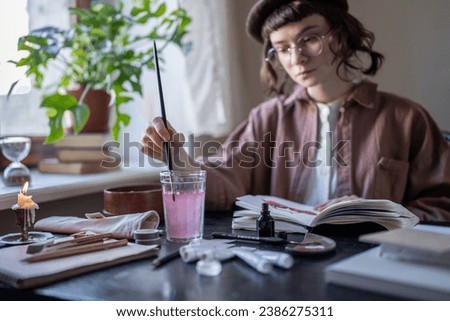 Animated cartoon artist drawing with brush in cozy studio, workshop, artist room. Serious girl in glasses, vintage clothes, beret creating animation. Girl with professional skills, talent, imagination