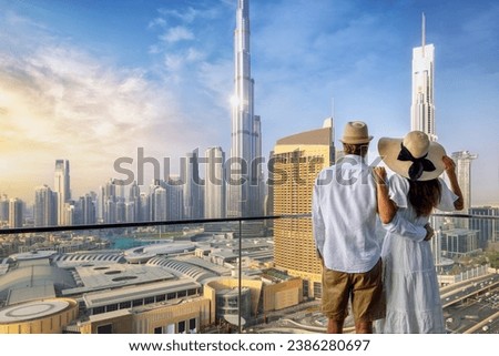 A couple on holidays enjoys the panoramic view over the city skyline of Dubai, UAE, during sunrise Royalty-Free Stock Photo #2386280697