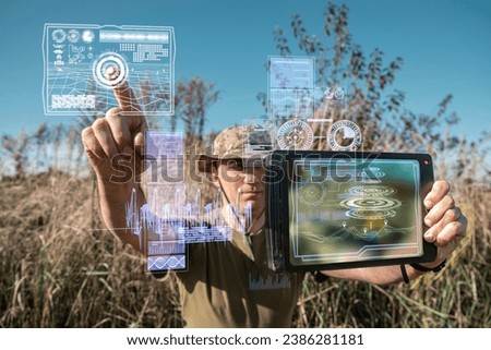 AI technology in the army. Warfare analytic operator checking coordination of the military team. Military commander with a digital tablet device with artificial intelligence operating troops outdoors. Royalty-Free Stock Photo #2386281181