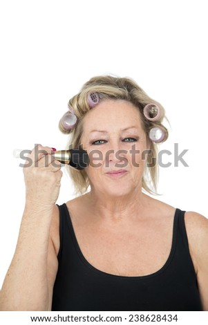 Beautiful blonde woman using a makeup brush against a white background