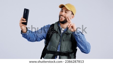 Hiking, smile and man with selfie, peace sign and social media with fun on white studio background. Person, model and hiker with a smartphone, profile picture and adventure with blog, journey or post