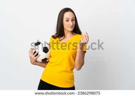 Young football player woman over isolated white background making money gesture