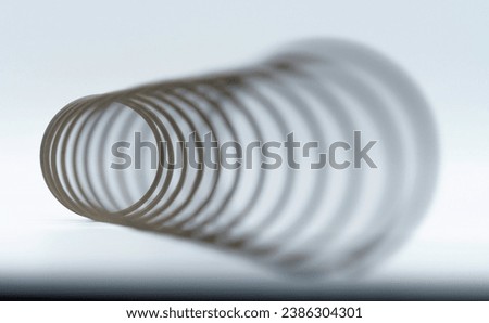 Cornucopia-like angular macro view of a  spring with the distant end in focus, giving the optical illusion that it is the near end. Royalty-Free Stock Photo #2386304301