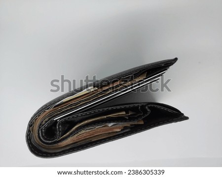 A wallet containing a lot of money. black wallet and filled with money. wallet on white background
