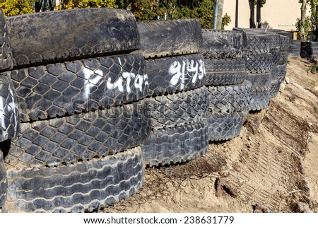 Disposal pile of old tires in the form of security fencing for spectators during the competition dangerous cars on a closed track cars