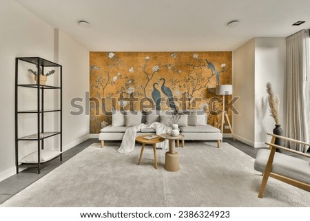 a bird painted on the wall in a living room with two chairs and a coffee table sitting next to it Royalty-Free Stock Photo #2386324923
