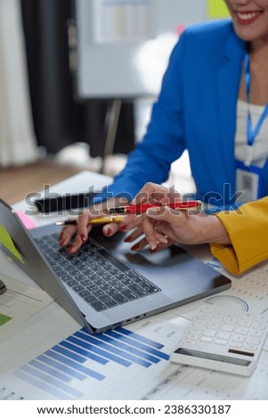 Team of creative businesswomen plan strategic analysis and brainstorm with financial reports, tax documents, calculations, analyze marketing processes with laptops in the office.