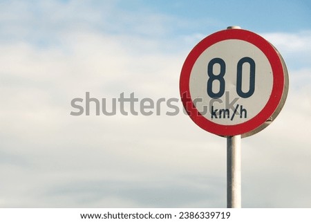 Travel concept. Information board on road. Speed limitation 80 km h sign. Close up. Text space. Outdoor shot Royalty-Free Stock Photo #2386339719