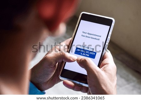 A South Asian man checking smartphone notification for his upcoming appointment. Online appointment booking and scheduling concept. Royalty-Free Stock Photo #2386341065