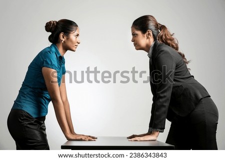 Indian business women staring at each other.  Two business rivals having a standoff. Royalty-Free Stock Photo #2386343843
