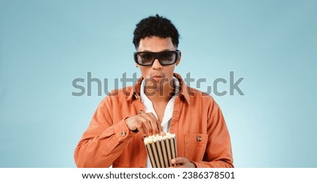 Man popcorn and studio with glasses for 3d movie with eating snack, streaming video and cinema by blue background. Person, sunglasses and corn fast food to watch show, cartoon and film in theater